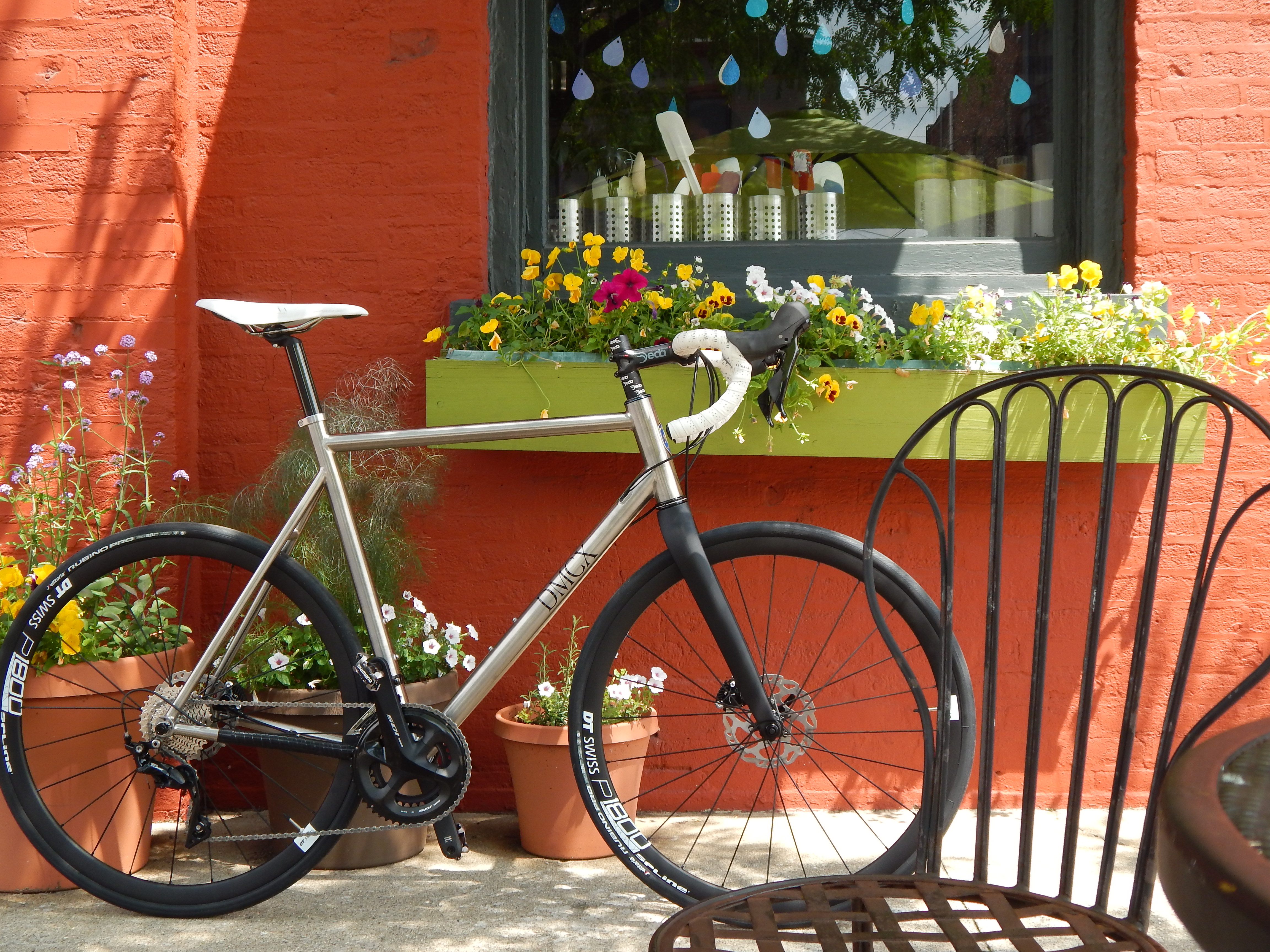 photo of titanium gravel bike front of red wall